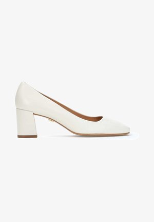 Chaussure à talon bloc en cuir blanc avec un design à bout arrondi et une texture lisse, présentant un intérieur beige subtil et un accent doré près du talon.