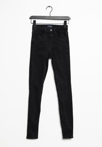 Jeans ajustados negros de mezclilla. Con una cintura alta, cinco bolsillos y un cierre clásico de botón y cremallera. Textura suave, sin patrones.