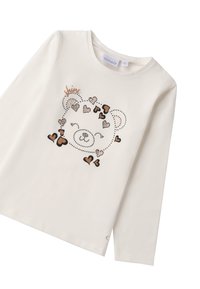 Langärmliges, cremefarbenes Baumwoll-T-Shirt mit einem zentralen Grafikmotiv aus Herzen und einem lächelnden Gesicht in verschiedenen Farbtönen und metallischen Akzenten.