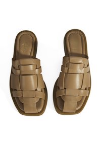 Braune Leder-Schlippersandalen mit einem geflochtenen Riemendesign. Gepolsterte Fußbett und Gummisohle. Minimalistischer Stil, flacher Absatz.