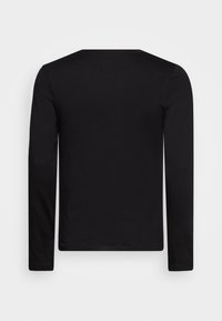 T-shirt noir à manches longues en coton doux, avec un col rond et un design simple, sans motifs ni graphiques.