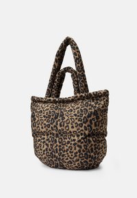 Sac fourre-tout rembourré en imprimé léopard avec deux paires de poignées douces et arrondies sur fond blanc.