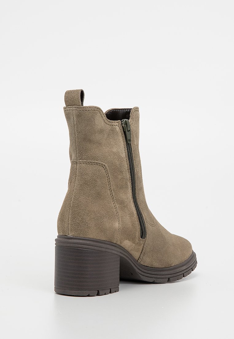 Olijfgroene suède enkellaars met een zijrits, een gestapeld hak, een ronde neus en een gestructureerd oppervlak. Geschikt voor casual of semi-formele draagstijl.