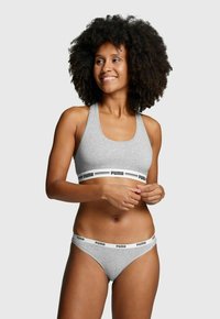 Grauer Sport-BH und Bikini-Set aus weichem Stoff, mit einem schwarzen "PUMA"-Logo-Bund. Der BH hat breite Träger und einen runden Ausschnitt.