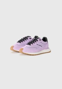 Purple suede sneakers with black accents, featuring a rubber sole, round toe, and black laces. Branding on the side.