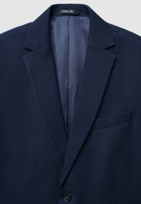 Blazer blu navy a fantasia con tessuto testurizzato, rever a punta, chiusura con singolo bottone e taschino sul petto, dotato di fodera interna liscia.