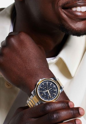 Silber- und goldfarbene Edelstahlarmbanduhr mit einem schwarzen Zifferblatt, die über Chronographenfunktionen und ein strukturiertes Armband verfügt.