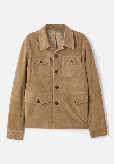 Τα μπεζ σουέτ μπουφάν διαθέτει κλασικό γιακά, τέσσερις μπροστινές τσέπες και κλείσιμο με κουμπιά. Έχει λεία υφή και εφαρμογή κομμένη στα μέτρα.