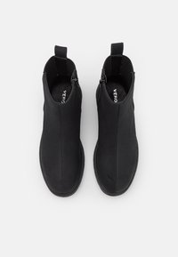 Černé kotníkové boty s hladkým matným povrchem, elastickými postranními panely a poutkem. Mají zaoblenou špičku a texturovanou podrážku.
