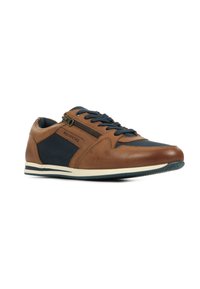 Bruine leren en marineblauwe canvas sneaker met een zijrits, contrasterende texturen, ronde neus en een witte rubberen zool met een marineblauw accent.