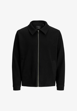 Schwarze Zip-Jacke mit spitzem Kragen, gerippter Textur, Seitentaschen und silbernem Reißverschluss. Einfaches, modernes und vielseitiges Design.