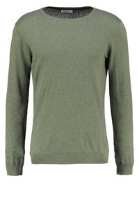 Olivgrön långärmad tröja i mjukt, texturerat stickat material. Har en rund halsringning och ribbade manschetter och fåll. Enkelt, klassiskt design.