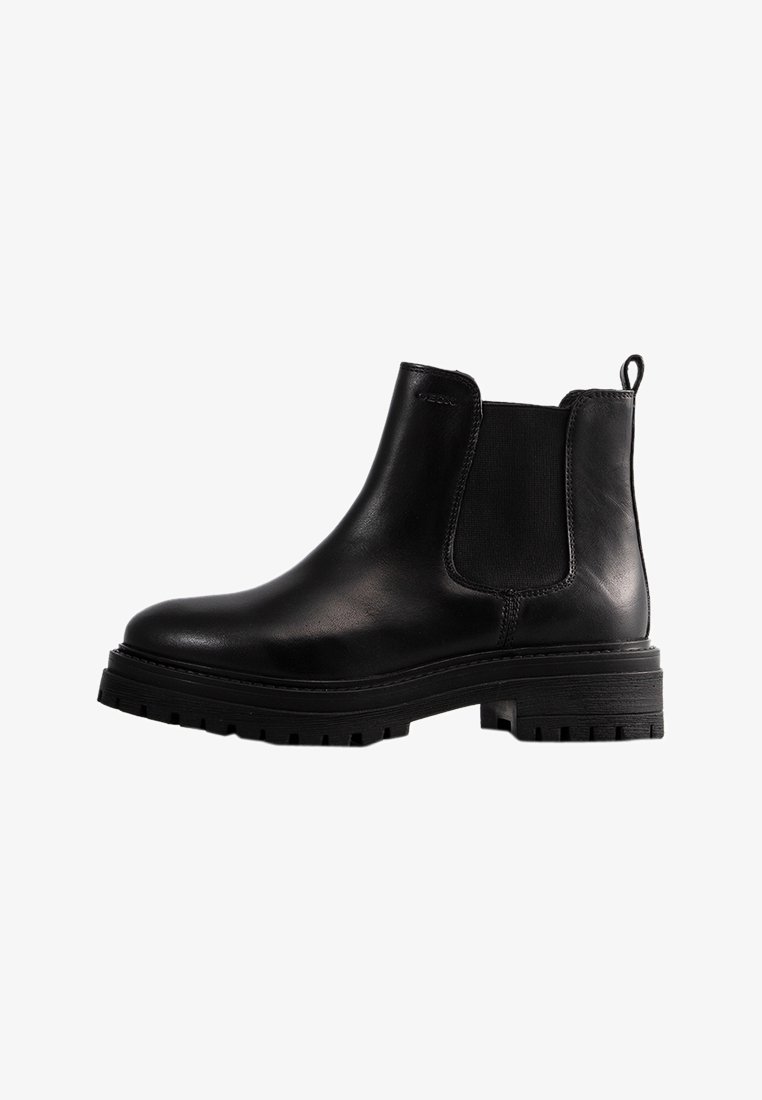 Botte Chelsea en cuir noir avec panneaux latéraux élastiques, bout arrondi, semelle épaisse antidérapante, et languette à l'arrière.