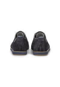 Scarpe in suede blu navy con profilo basso, punta arrotondata e suola in gomma marrone a contrasto. Presentano cuciture minimal e una superficie testurizzata.