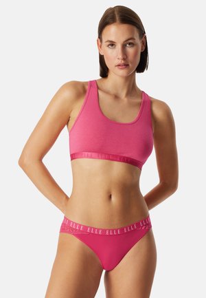 Roze katoenen sportbh en bijpassende string, beide met een textuurband met de merknaam. Gladde stof, rekbare pasvorm, zonder padding.