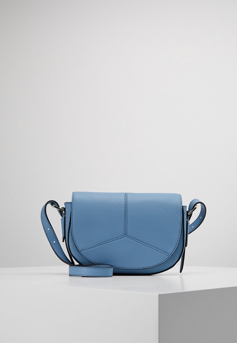 Niebieska skórzana torba na ramię z regulowanym paskiem, zakrzywioną klapą i geometrycznym przeszyciem, prezentowana na białym postumencie na jednolitym tle.