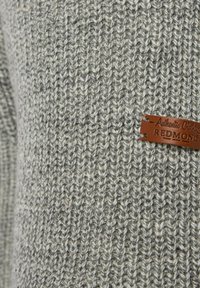 Grauer Strickpullover mit strukturiertem Muster und einem braunen Lederetikett mit der Aufschrift "Authentic Clothing REDMOND."