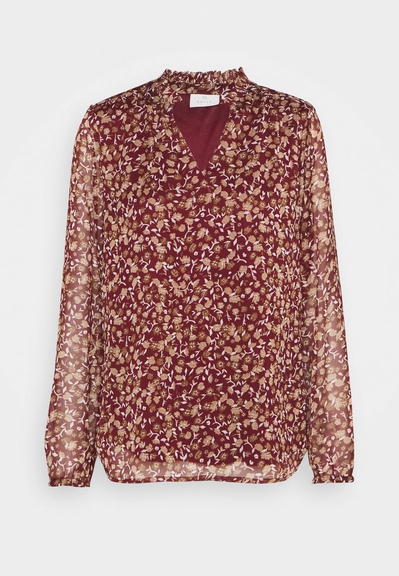 Blouse bordeaux à manches longues avec un motif floral, décolleté en V bordé de volants, et tissu transparent sur les manches.