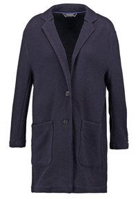 Námořnický modrý kabát z texturované tkaniny, s klopovým límcem, dvěma předními kapsami a dvěma knoflíky na přední straně.