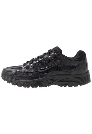 Schwarzer Sportschuh mit Mesh-Einsätzen, überkreuzten Overlays, Nike-Swoosh-Logo und dicker, strukturierter Sohle.