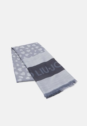 Écharpe grise pliée avec des motifs de cœurs blancs et une bande gris foncé portant partiellement le nom de la marque "LIU·JO" et des bords effilochés.