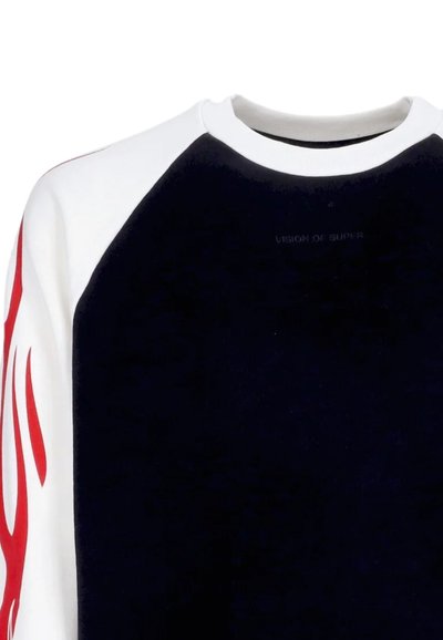 Felpa nera con maniche raglan bianche e design di fiamma rossa sulla manica sinistra. Presenta un collo rotondo e un branding discreto sul petto.