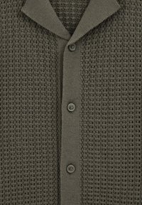 Cardigan en maille vert foncé avec un motif gaufré texturé, un col pointu et trois boutons assortis sur le devant.