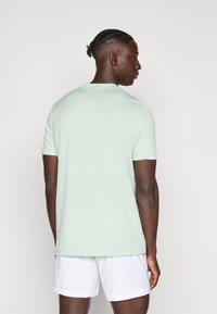 Μέντα πράσινο αθλητικό μπλουζάκι με κοντά μανίκια, διαθέτει υφασμένο ριμπ μοτίβο, στρογγυλή λαιμόκοψη και ελαφρώς εφαρμοστή σιλουέτα.