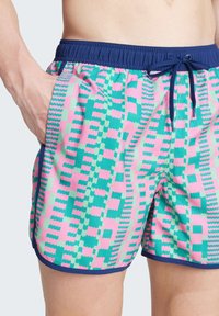 Plavky z vzorované látky v růžové, zelené a modré barvě, s námořnickým páskem a stahovací šňůrkou, s bočními kapsami.