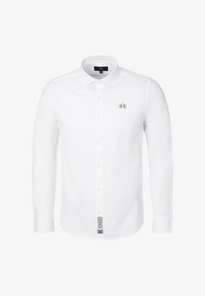 Weißes, langärmliges Hemd mit Knopfleiste, klassischem Kragen, besticktem Logo auf der linken Brust und einem Pflegeetikett aus Stoff nahe dem unteren Vorderteil.