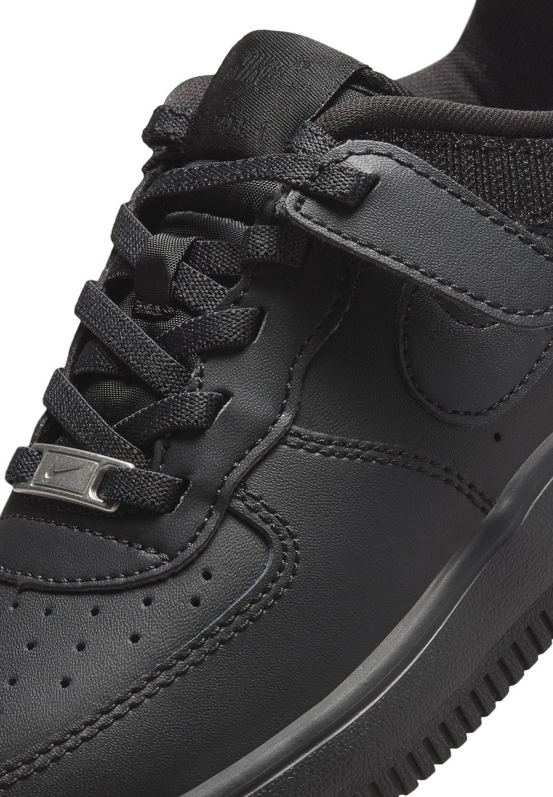 Basket en cuir noir avec une surface texturée, dotée d'un design à lacets, d'un accent avec logo argenté et d'une semelle en caoutchouc avec de petites perforations.