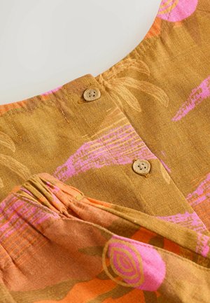 Ruskea kangas, jossa on vaaleanpunainen ja oranssi abstrakti kukkakuosi, kaksi pientä pyöreää puunappia ja alaspäin kerätty ommel alaosassa.