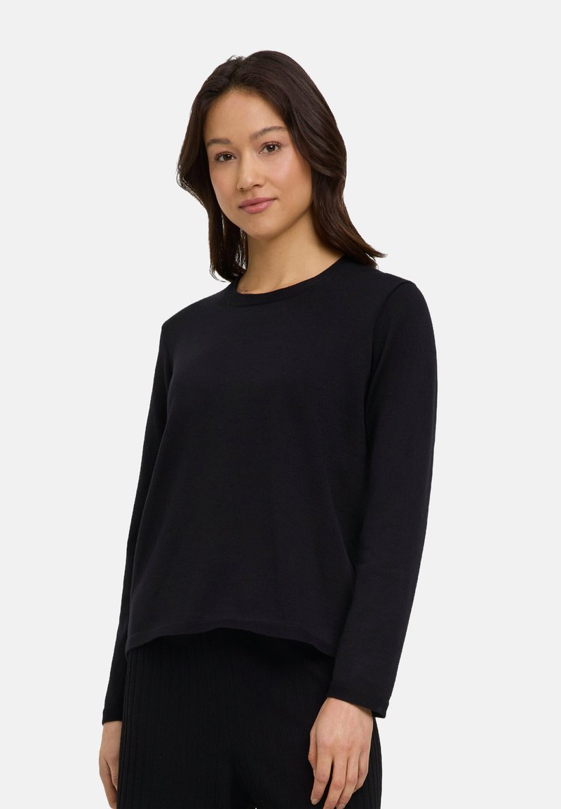 Schwarzes Langarmshirt aus weichem Stoff, mit rundem Halsausschnitt und lockerer Passform, sichtbar genäht an den Ärmeln und dem Saum.