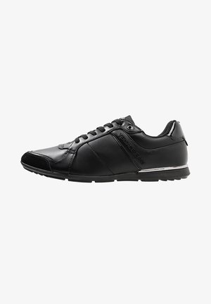 Baskets en cuir noir Versace Jeans avec fermeture à lacets à l’avant, semelle profil bas et marquage embossé discret sur le côté.