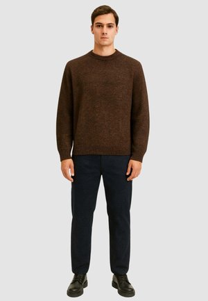 Maglione marrone lavorato a maglia con scollatura rotonda, polsini e orlo a coste. Abbinate a pantaloni scuri e scarpe nere stringate. Design semplice.