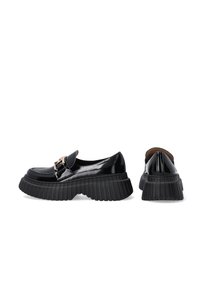 Schwarze Lackleder-Plateauschuhe mit einer geriffelten Sohle, einer abgerundeten Spitze und einer dekorativen goldenen Schnalle auf dem Obermaterial.
