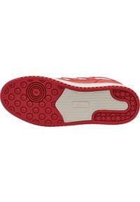 Rød sneakersål med struktureret overflade, cirkulære mønstre og hvid mellemsål. Har gummimateriale og et fladt, holdbart design.