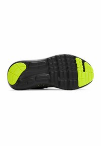 Semelle de chaussure de sport noire en caoutchouc texturé avec une accentuation verte. Les motifs notables comprennent des rainures circulaires et en forme de vagues pour l'adhérence.