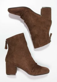 Braune Wildleder-Stiefeletten mit Blockabsatz, Reißverschluss und gerafftem Design, mit einer glatten Oberfläche und schmaler Zehenpartie.