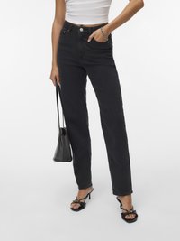 Fekete, magas derekú, egyenes szárú farmernadrág, gombos rögzítéssel, elülső zsebekkel és letisztult dizájnnal. Fekete, magas sarkú szandállal párosítva.