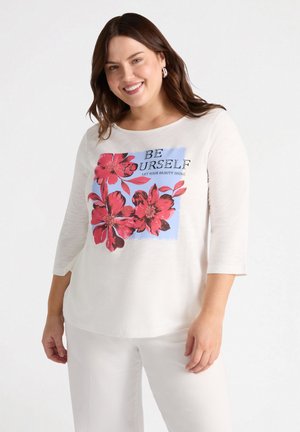 T-shirt in tessuto morbido di colore chiaro con un design grafico floreale in rosso e blu, con il testo "SII TE STESSO" stampato al centro.