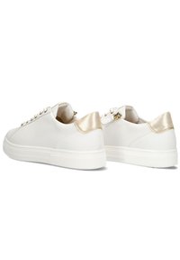 White sneakers with a smooth finish, gold accent at the heel, round toe, lace-up design, and textured rubber sole.