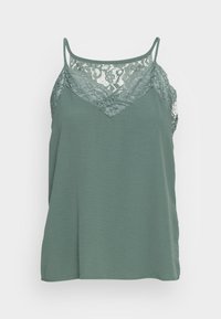 Top caraco vert avec un empiècement en dentelle au niveau de l'encolure, des bretelles ajustables et une coupe décontractée en tissu doux et texturé.