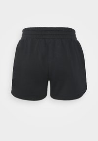 Pantalones cortos de algodón negros con cinturilla elástica, que presentan una textura suave y un ajuste holgado. El dobladillo es ligeramente curvado.