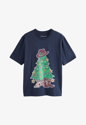 T-shirt di cotone blu navy con una grafica in stile cartone animato di un albero di Natale che indossa un cappello marrone e stivali da cowboy, decorato con ornamenti colorati.