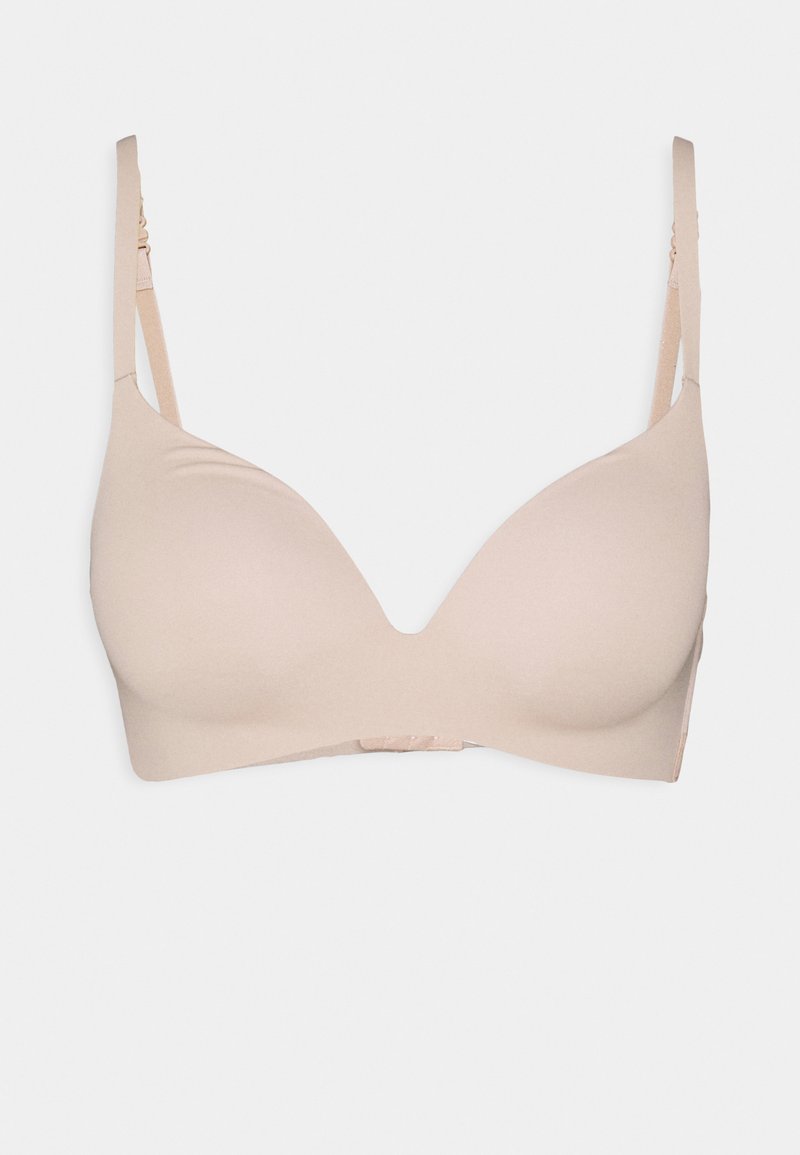 Light beige bra with smooth, molded cups, adjustable straps, and a secure hook-and-eye closure. Minimalist design, no visible patterns.