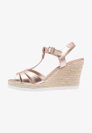 Sandale compensée métallique en or rose avec un design à lanière en T, talon enveloppé de jute et semelle en caoutchouc blanc. Comprend des lanières croisées pour le soutien.