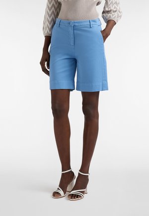 Pantaloncini azzurri in tessuto intrecciato, con davanti piatto, passanti per cintura e tasche laterali, tagliati appena sopra il ginocchio.