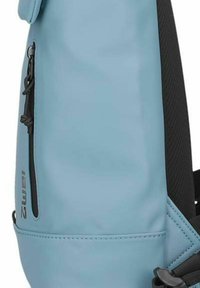 Teal accessory backpack with a smooth synthetic surface, featuring a side zipper pocket and black mesh accents. Durable and practical design.