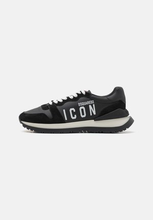 Baskets noires en cuir et en daim, avec un logo "ICON" blanc et une semelle noire contrastante. Les lacets sont blancs ; le design est sportif.